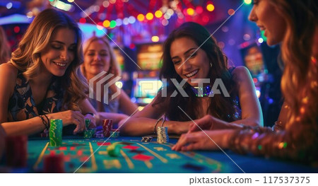 Three women place a bet playing roulette at the casino 117537375
