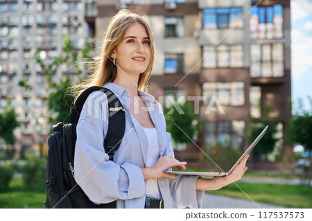 Young female college student using laptop computer outdoor Young female college student using laptop computer outdoor 117537573