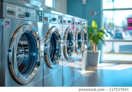 A row of industrial washing machines in a public laundromat 117537691