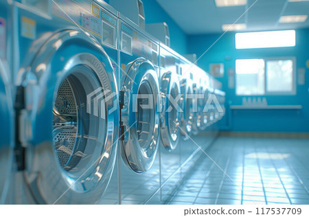 A row of industrial washing machines in a public laundromat 117537709