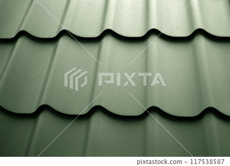 Close-up view lightweight steel roofing sheet. Green color coated modular tile effect roof panel. Traditional metal shingle tiles. Popular profiled metallic pantile mimic clay or concrete slate 117538587