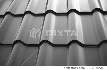 Close-up view lightweight steel roofing sheet. Black color coated modular tile effect roof panel. Traditional metal shingle tiles. Popular profiled metallic pantile mimic clay or concrete slate 117538589