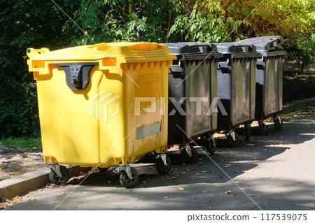 Garbage bins. Dumpsters being full with garbage in park. Garbage waste lots junk dump. 117539075