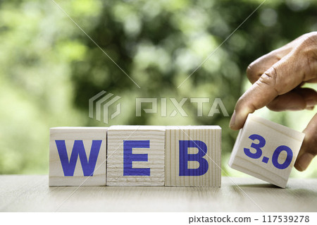 Web 3.0 icon in wood on green background. Businessman hand turns cubes and changes the word web 3.0.Technology and WEB 3.0 concept. 117539278