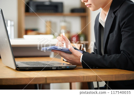 穿著西裝的女人在家操作平板電腦 穿著西裝的女人在家操作平板電腦 117540035