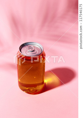 Transparent can mockup containing fizzy, amber-hued drink, beer, lemonade, soda water, set against pink background with shadow element creating summer chilling and refreshing vibes. Transparent can mockup containing fizzy, amber-hued drink, beer, lemonade, soda water, set against pink background with shadow element creating summer chilling and refreshing vibes. 117540175