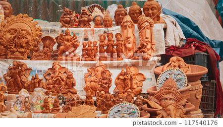 Statues Of Buddha Head And Ganesha On Market. Popular Souvenirs From India. selling pots, vases and other Oriental Ceramic Traditional Handmade Clay dishware Jugs On The Main Bazar market place 117540176