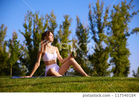 Taking moment to refuel with powerful, nutrient-rich drink, perfect for energy restoration and recovery after her yoga routine Taking moment to refuel with powerful, nutrient-rich drink, perfect for energy restoration and recovery after her yoga routine 117540184