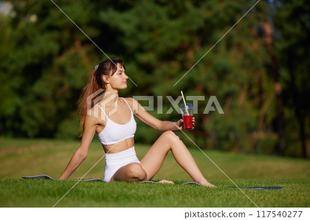 Young woman dressed activewear rest during yoga session, drinks adds nutrition and refreshes during breaks between approaches. 117540277