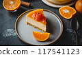 Fresh orange marmalade-topped cheesecake slice with orange slices on a plate. Creamy dessert. 117541123