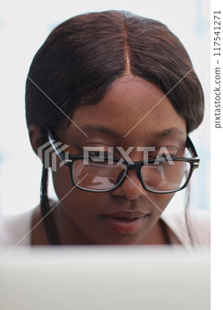 female employee or a businesswoman using a laptop in a modern office female employee or a businesswoman using a laptop in a modern office 117541271