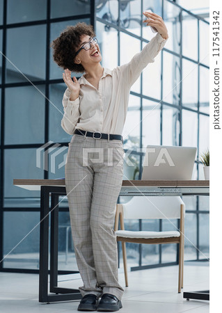 girl in the office smiles expresses success takes a selfie girl in the office smiles expresses success takes a selfie 117541342