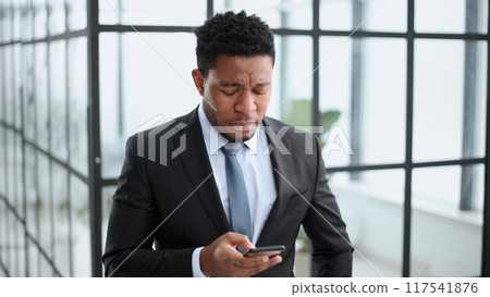 attractive african american young man uses phone 117541876