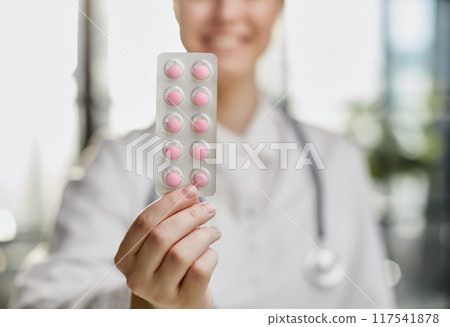 Close up portrait female doctor scientist pharmacist looking at camera presenting new effective pill medicine. 117541878
