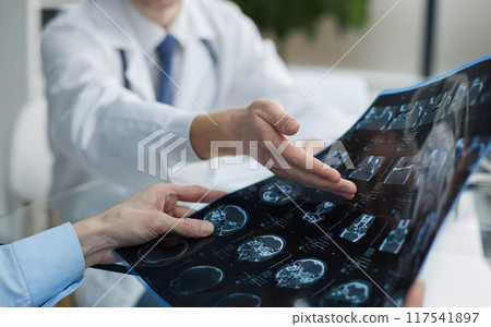 shows the x-ray image to the patient at the reception 117541897