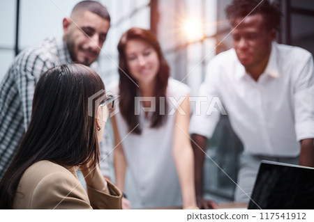Happy young female worker discussing online project, showing presentation to experienced team leader in glasses. 117541912