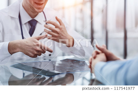 the doctor and the patient at the reception are discussing the x-ray 117541977