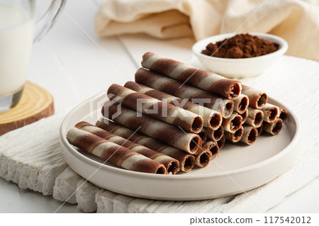 Chocolate cream flavour wafers sticks or wafer rolls in white plate.snack food. 117542012