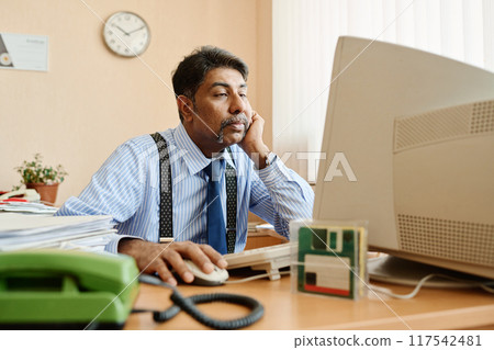 Working Professional Using Computer in Office Setting 117542481