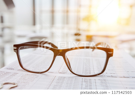 office desk with glasses and financial report office desk with glasses and financial report 117542503