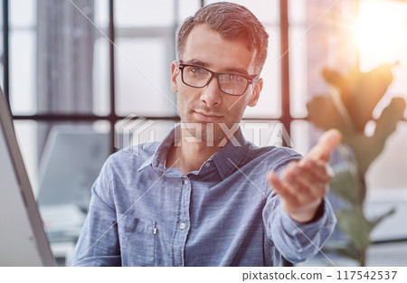 Young caucasian handsome man stretching hand at camera in greeting gesture. 117542537