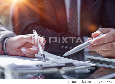Close-up. Businessman looking at financial report and making notes with a pen in it 117542669