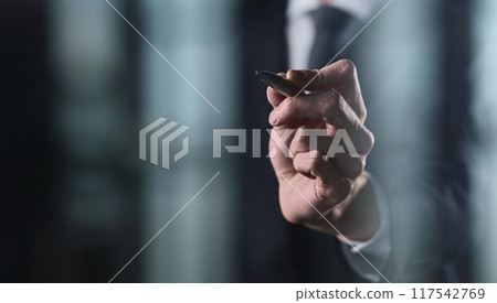 right hand writes with a marker on a transparent board on a black background 117542769