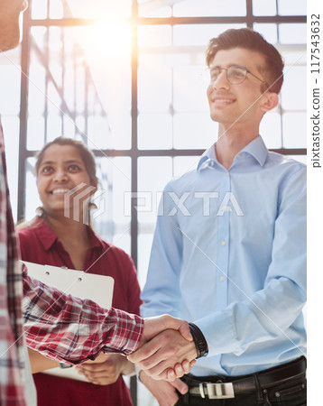 Two diverse professional business men executive leaders shaking hands at office meeting Two diverse professional business men executive leaders shaking hands at office meeting 117543632