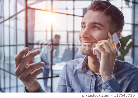 Businessman shopping over the phone in an office 117543730