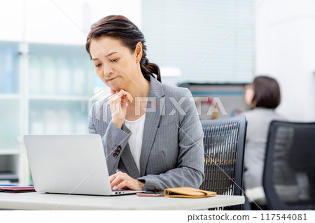 A businesswoman worried while looking at a computer screen A businesswoman worried while looking at a computer screen 117544081