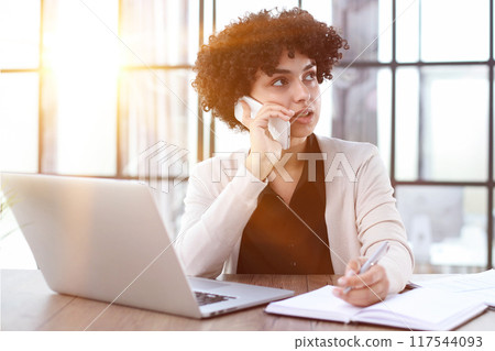 Portrait of Young Successful Caucasian Businesswoman Sitting at Desk Working on Laptop Portrait of Young Successful Caucasian Businesswoman Sitting at Desk Working on Laptop 117544093