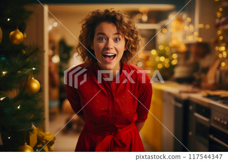 Cheerful Woman Adding Sparkle to Christmas Tree Cheerful Woman Adding Sparkle to Christmas Tree 117544347
