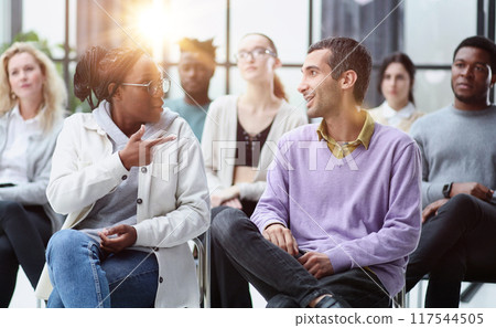 conducts business training with a group of young people. 117544505