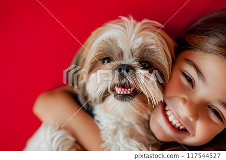 Pure Joy: Smiling Child and Playful Shih Tzu on Red 117544527