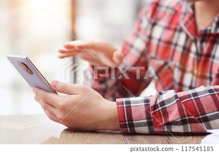 businessman holding smartphone sit in office working online on gadget. businessman holding smartphone sit in office working online on gadget. 117545185