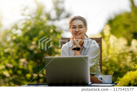 woman working on laptop in summer morning 117545577