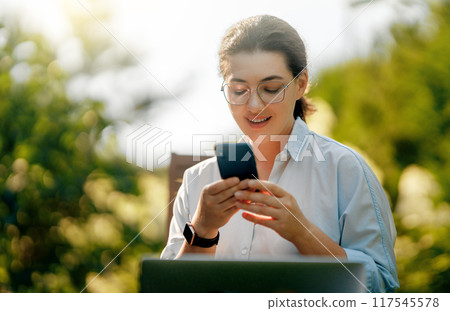 woman working on laptop in summer morning woman working on laptop in summer morning 117545578