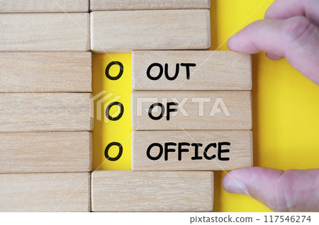 Hand pulling wooden blocks with Out Of Office. Out of office concept. 117546274