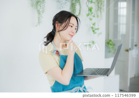 A woman in an apron thinking 117546399
