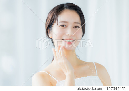 A young woman feels her skin become more moisturized 117546451