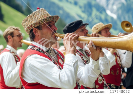 Traditional musicians playing alphorns with scenic Alpine landscape in background 117548032