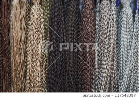 Artificial hair for braiding Afro-pigtails and hairstyles. Natural colors of zizi pigtails from kanekalon. Bright colors. Textured wallpaper. With space to copy. High quality photo 117548397