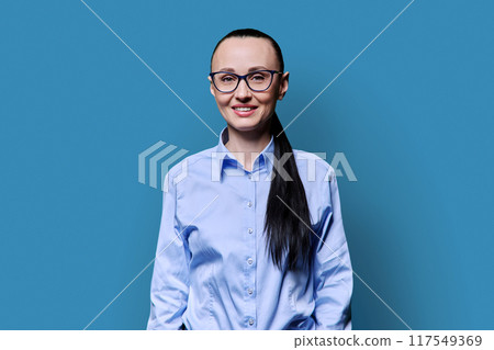 Portrait of smiling business middle aged woman on blue background 117549369