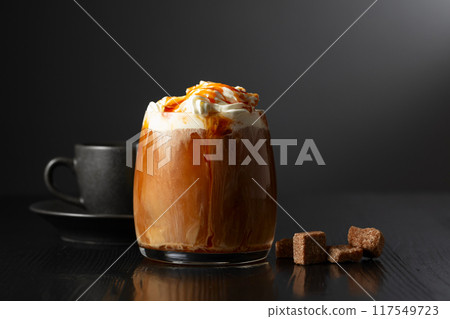 Iced coffee with whipped cream and caramel sauce and cup of black coffee. 117549723