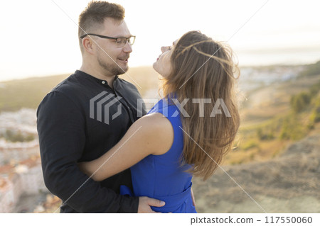 Loving couple embracing on mountain top at sunset 117550060