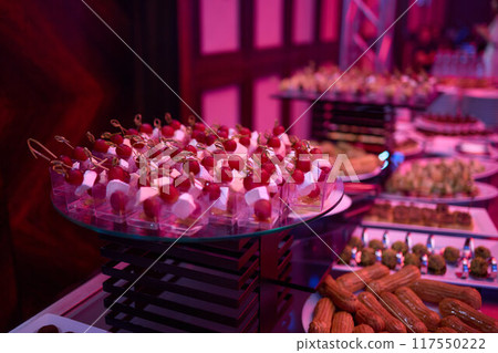 Buffet table with appetizers and finger foods, creating an elegant dining experience Buffet table with appetizers and finger foods, creating an elegant dining experience 117550222