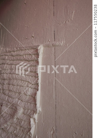 Carefully Hand Applying Plaster on a Wall Surface for Effective Home Renovation Tasks Carefully Hand Applying Plaster on a Wall Surface for Effective Home Renovation Tasks 117550238