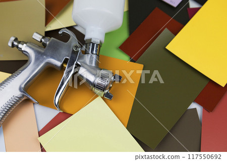 a paint spray gun at work at the workplace in the workshop. Paint samples. 117550692