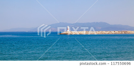 Lighthouse in the bay of Kusadasi. Lighthouse in the blue sea on a clear sunny day. 117550696