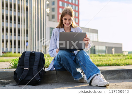Young female college student using laptop computer outdoor 117550943